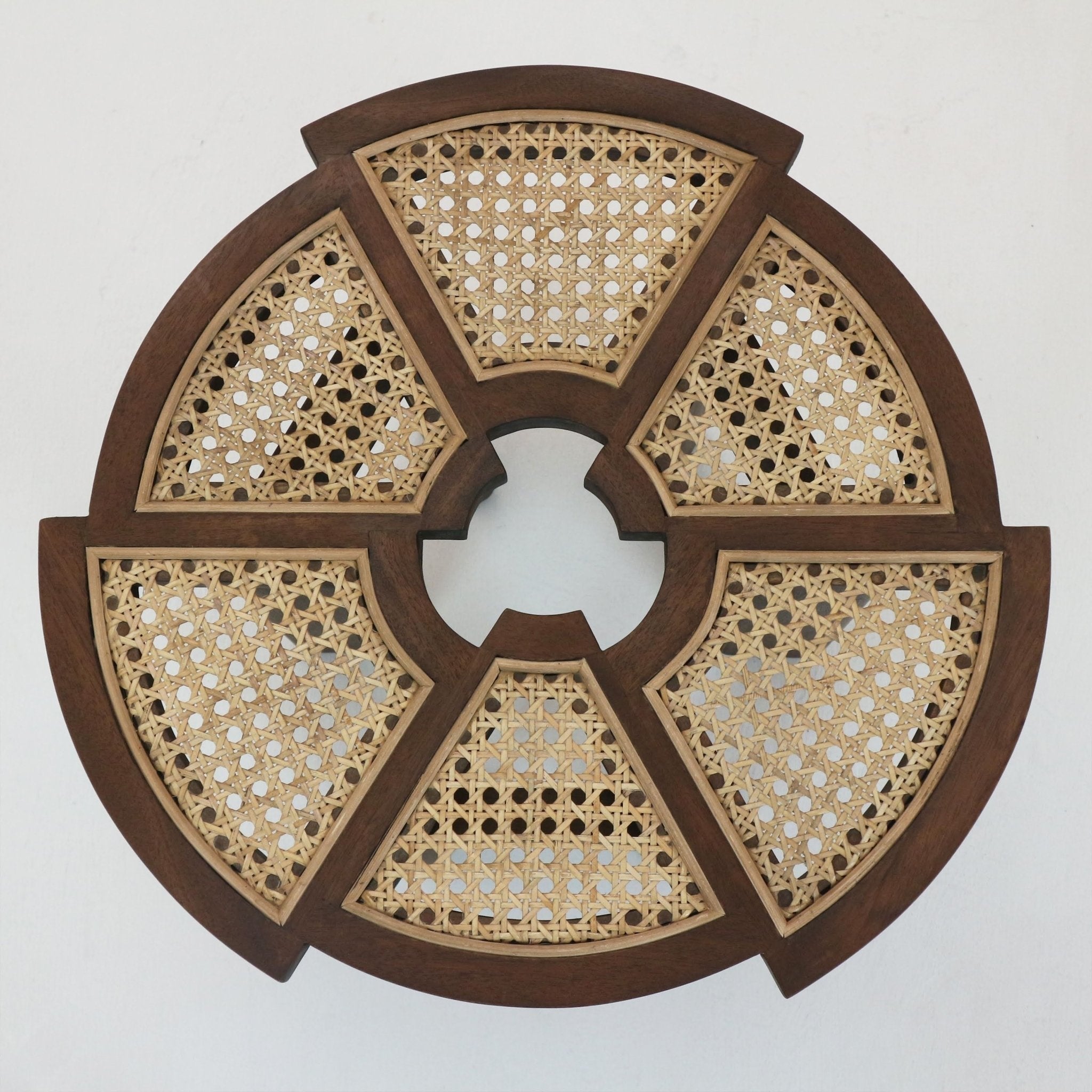 Round teak side table top in medium brown solid wood featuring six wedge-shaped panels of natural cane rattan inlay and a decorative circular center opening, shown against a white background.