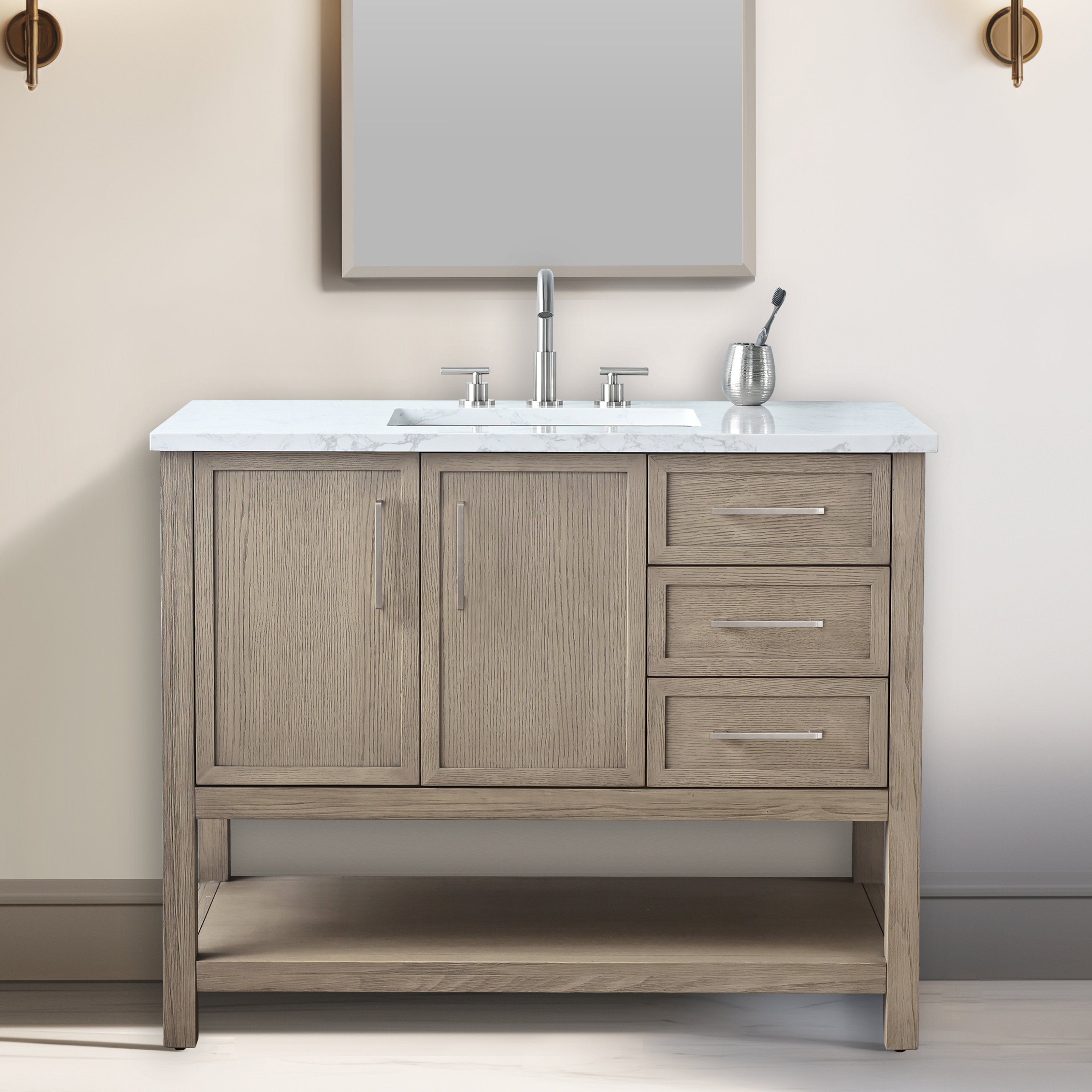 Modern light stone-finished solid wood bathroom vanity with white marble top, undermount sink and brushed nickel faucet, two paneled doors left, three drawers right, open bottom shelf and slim metal handles.
