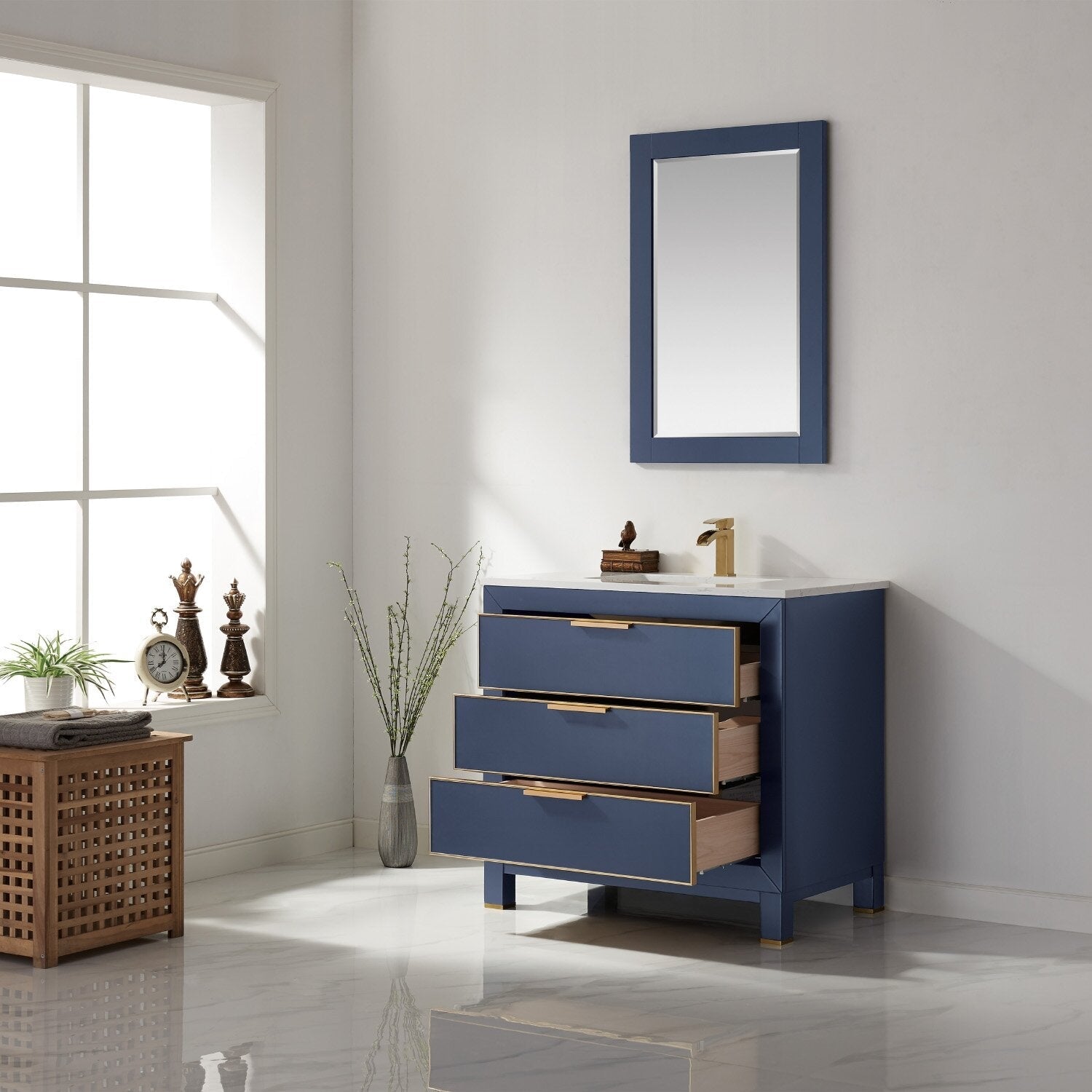 Freestanding 36-inch modern solid wood bathroom vanity with blue painted finish, white stone countertop and ceramic sink, three partially open drawers with gold hardware, matching mirror and brass faucet.