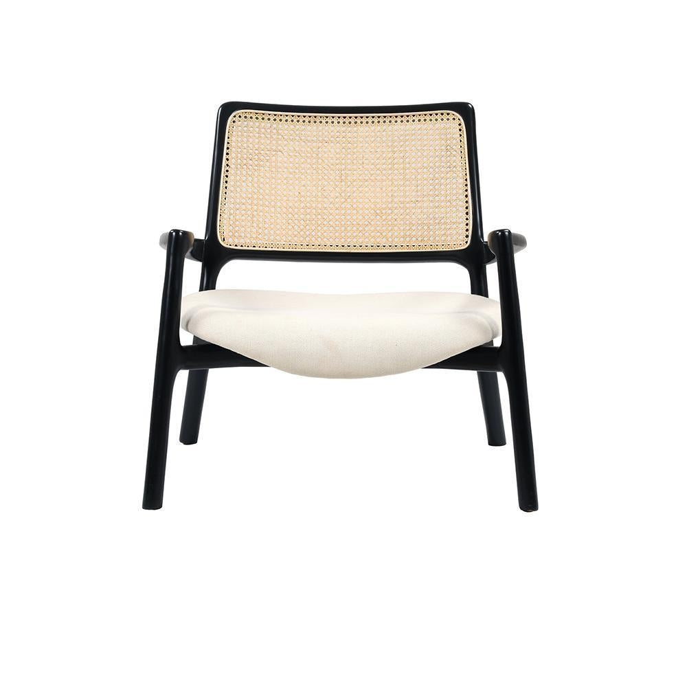 Front view of a modern mahogany wood lounge chair with a woven cane backrest and a cushioned ivory fabric seat, low-profile silhouette with curved armrests and angled legs on a white background.