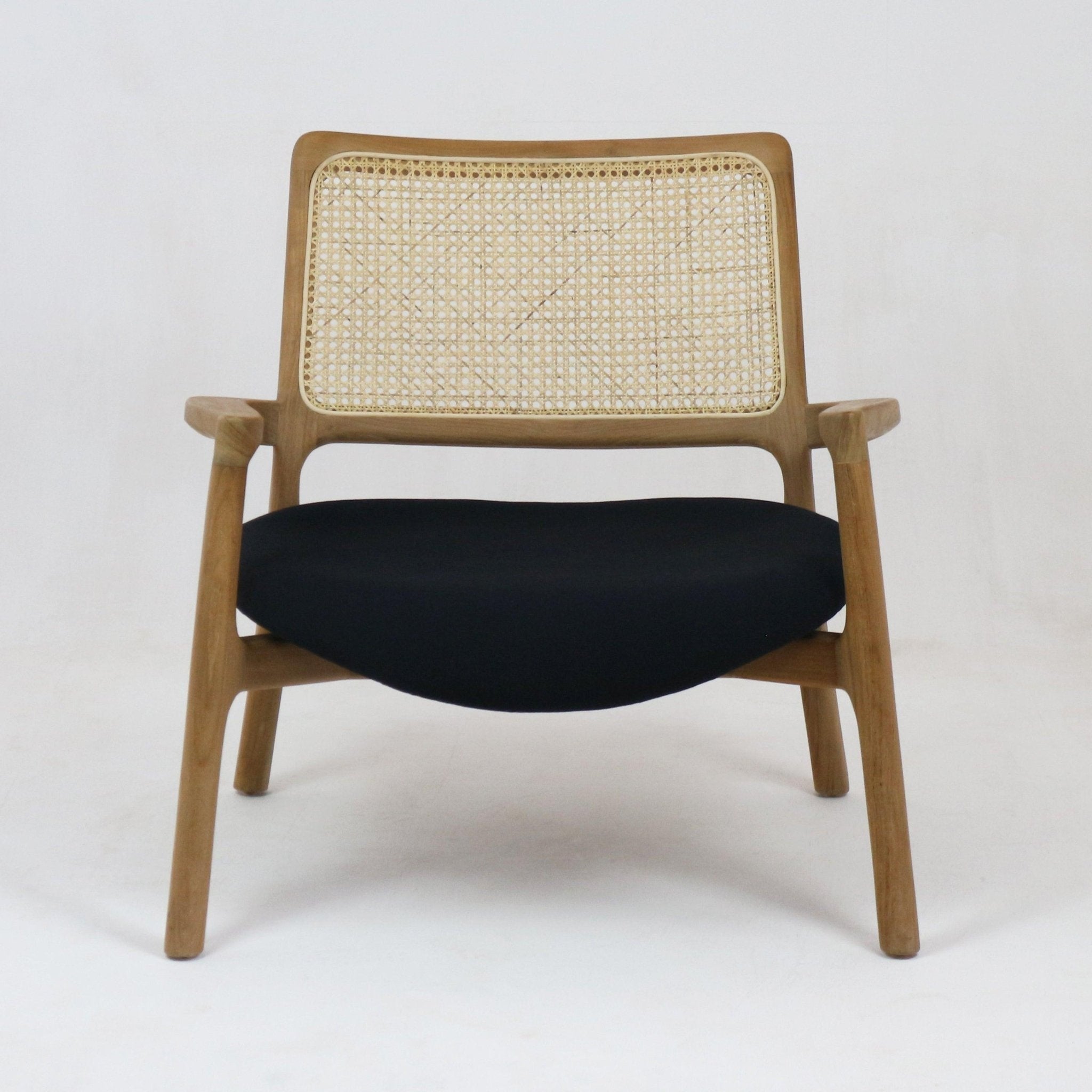 Mid-century modern lounge chair with a solid teak frame, woven cane backrest and a black upholstered fabric seat, shown front-facing on a white studio background.