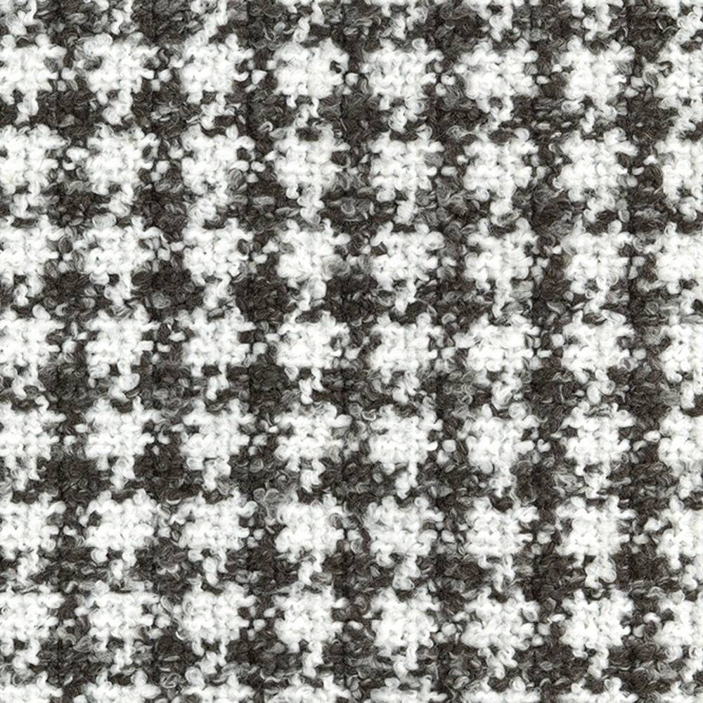 Close-up of a textured boucle upholstery fabric in white and dark gray showing a small-scale houndstooth pattern and looped yarn surface, suitable for contemporary sofa upholstery; 70% acrylic, 30% polyester.