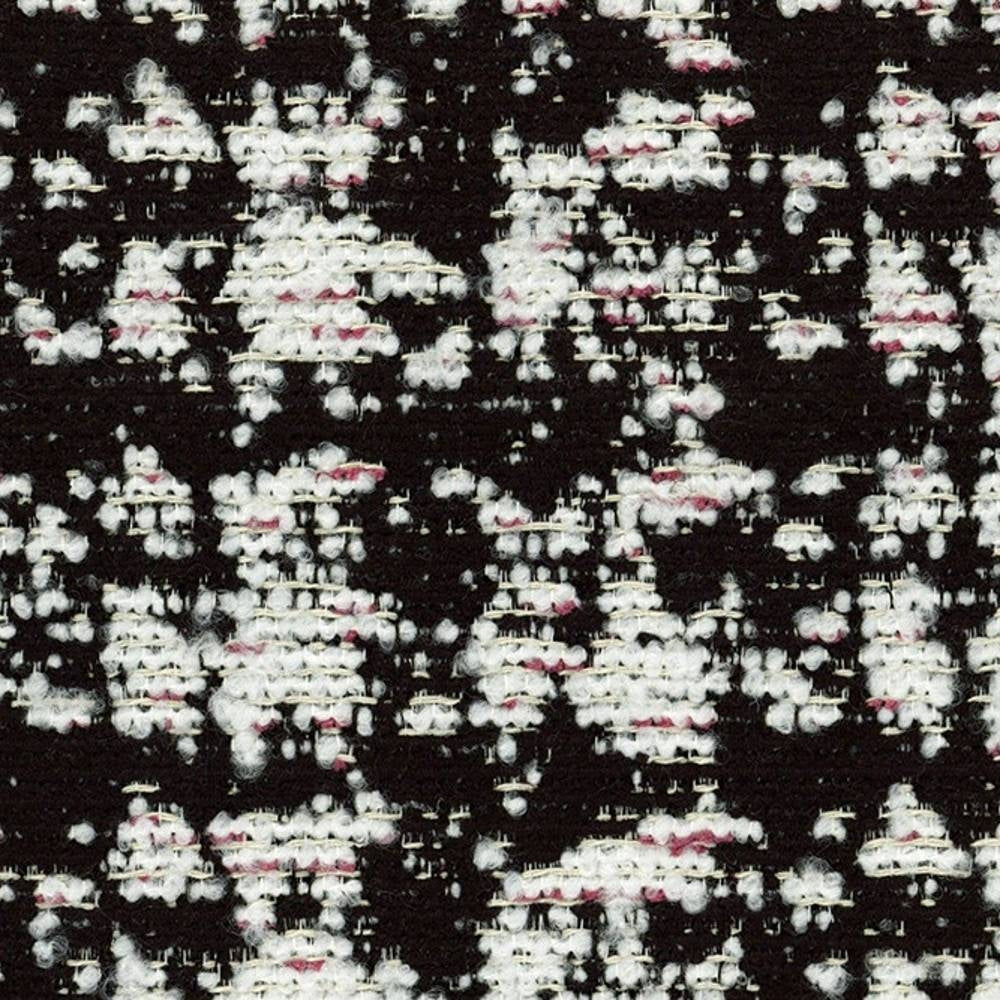 Close-up of black woven upholstery fabric showing dense white boucle clusters with subtle pink slubs on a textured 41% viscose, 9% acrylic, 50% polyester blend, suited for contemporary sofas.