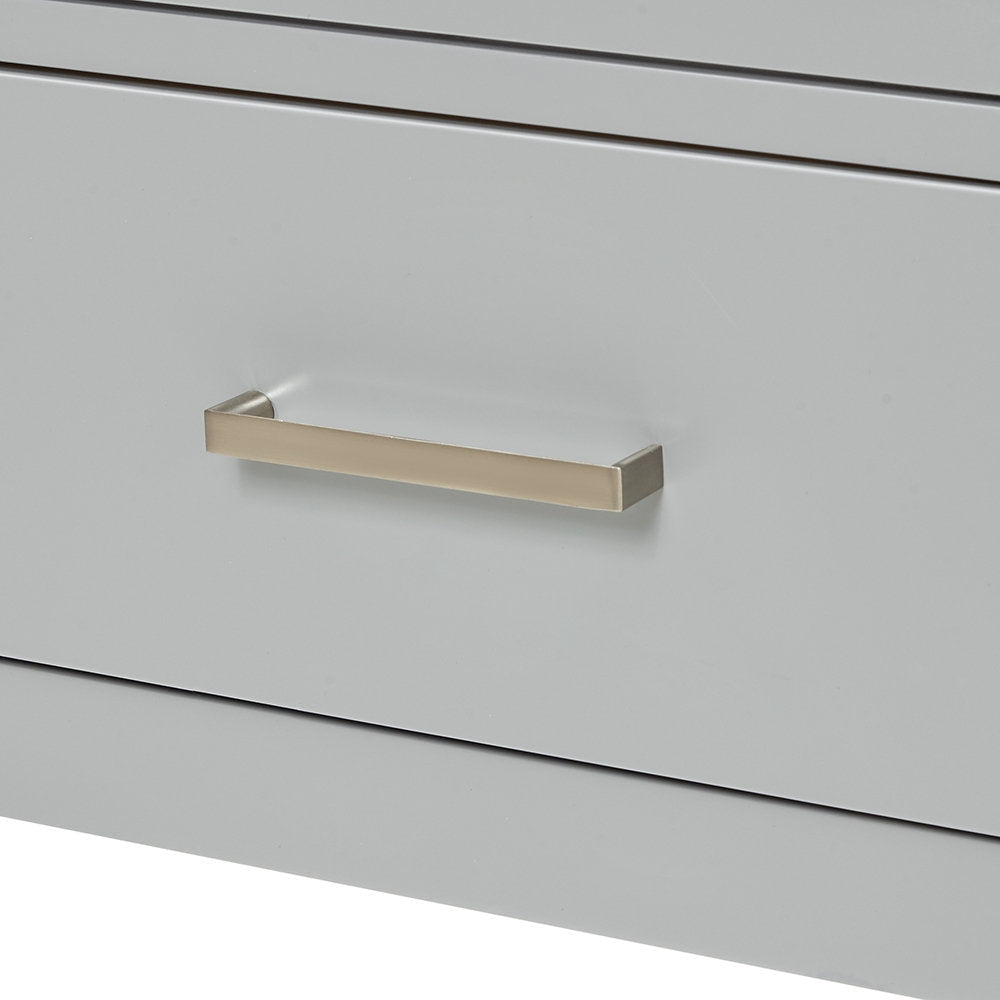 Close-up of a stone-colored wooden vanity drawer front showing a centered rectangular brushed-nickel bar handle and narrow recessed seams above and below the panel.
