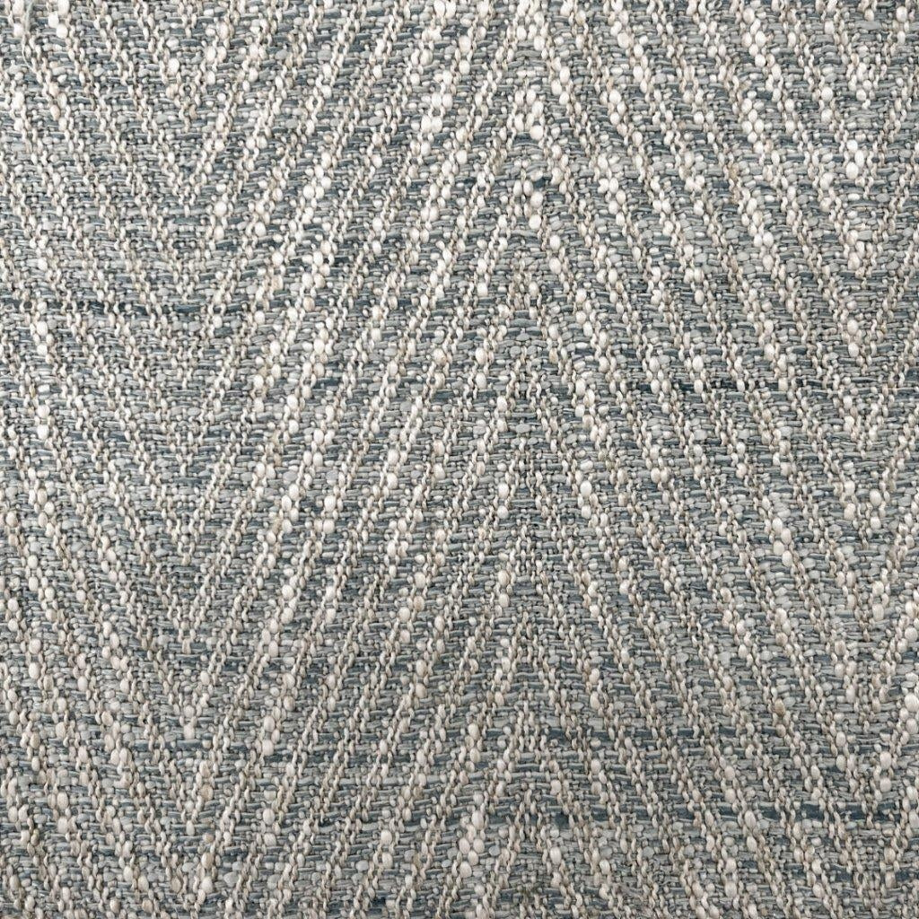 Close-up of lake herringbone upholstery fabric showing a textured chevron weave in blue-gray and cream yarns with raised boucle-like nubs.