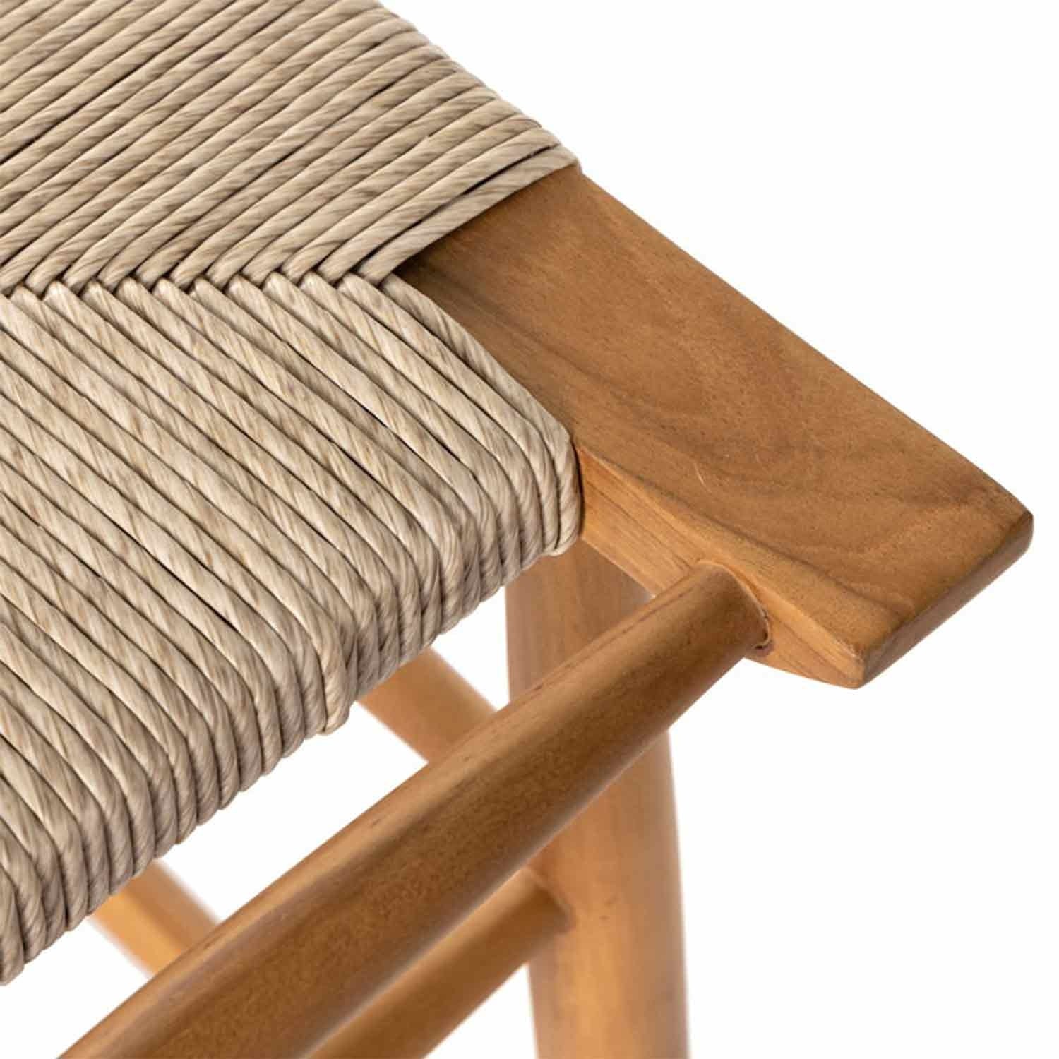 Close-up of a backless teak outdoor bar stool corner showing a natural teak wood frame and tightly woven beige rope seat, highlighting the woven detail and smooth wood grain.