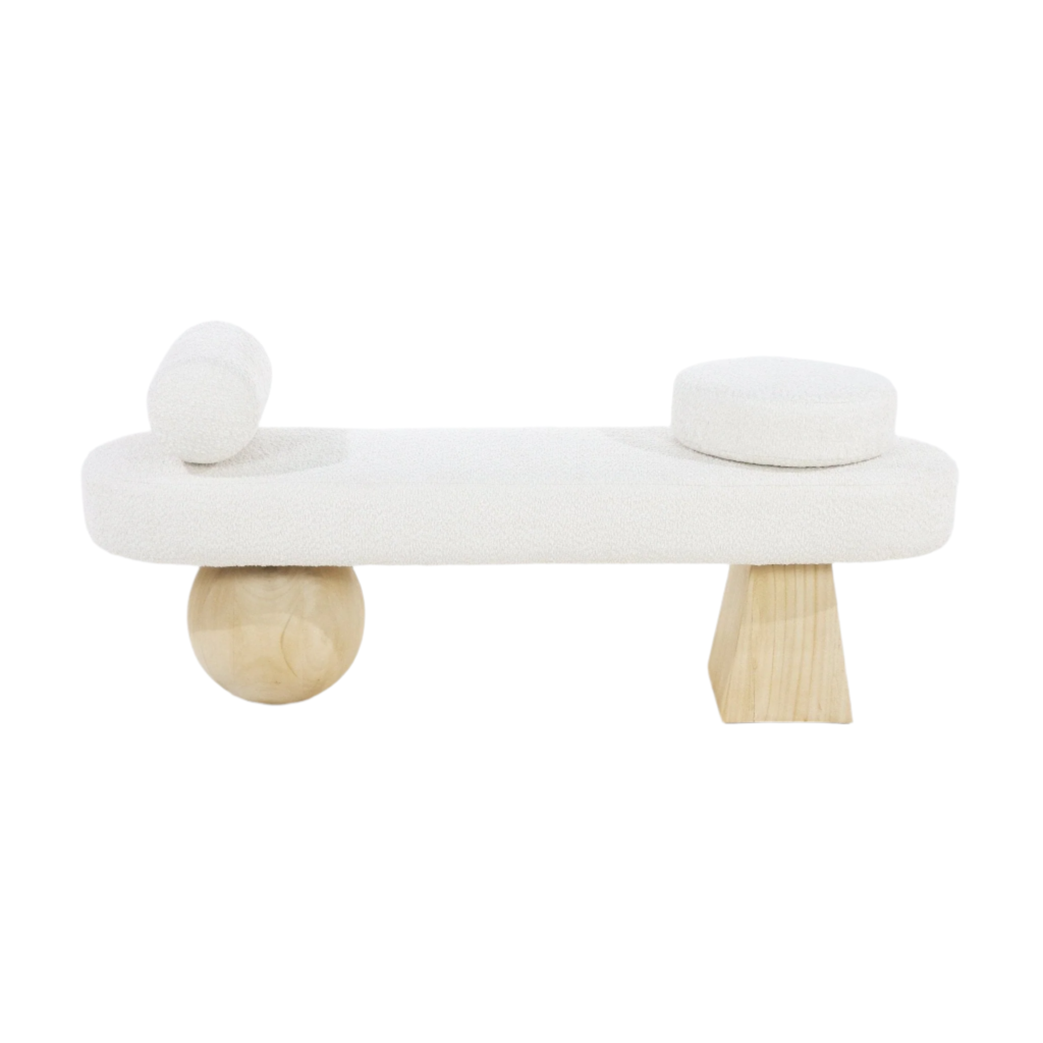 White boucle upholstered end-of-bed bench with a cylindrical bolster pillow on the left and a round cushion on the right, supported by sculptural natural wood legs — one spherical and one tapered.